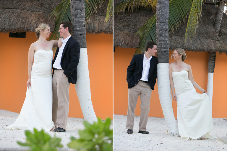 Wedding couple on beach in front of orange building.